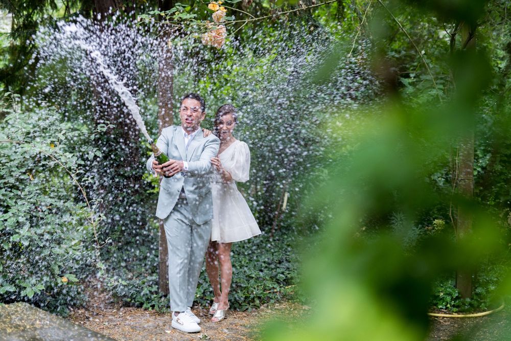 Couple juif sabrant une bouteille de champagne et eclaboussant tout autour et verre l'objectif du photographe de la clic.