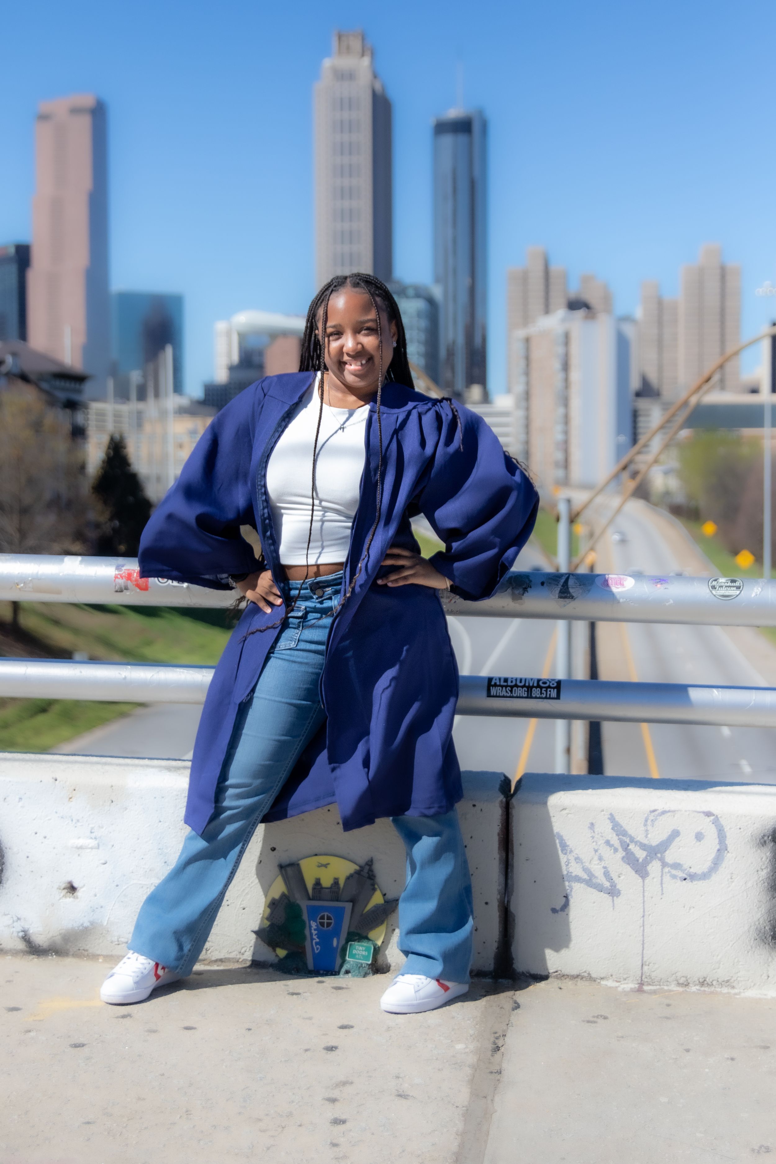 Urban fashion portrait with city skyline backdrop featuring casual streetwear and confident pose.