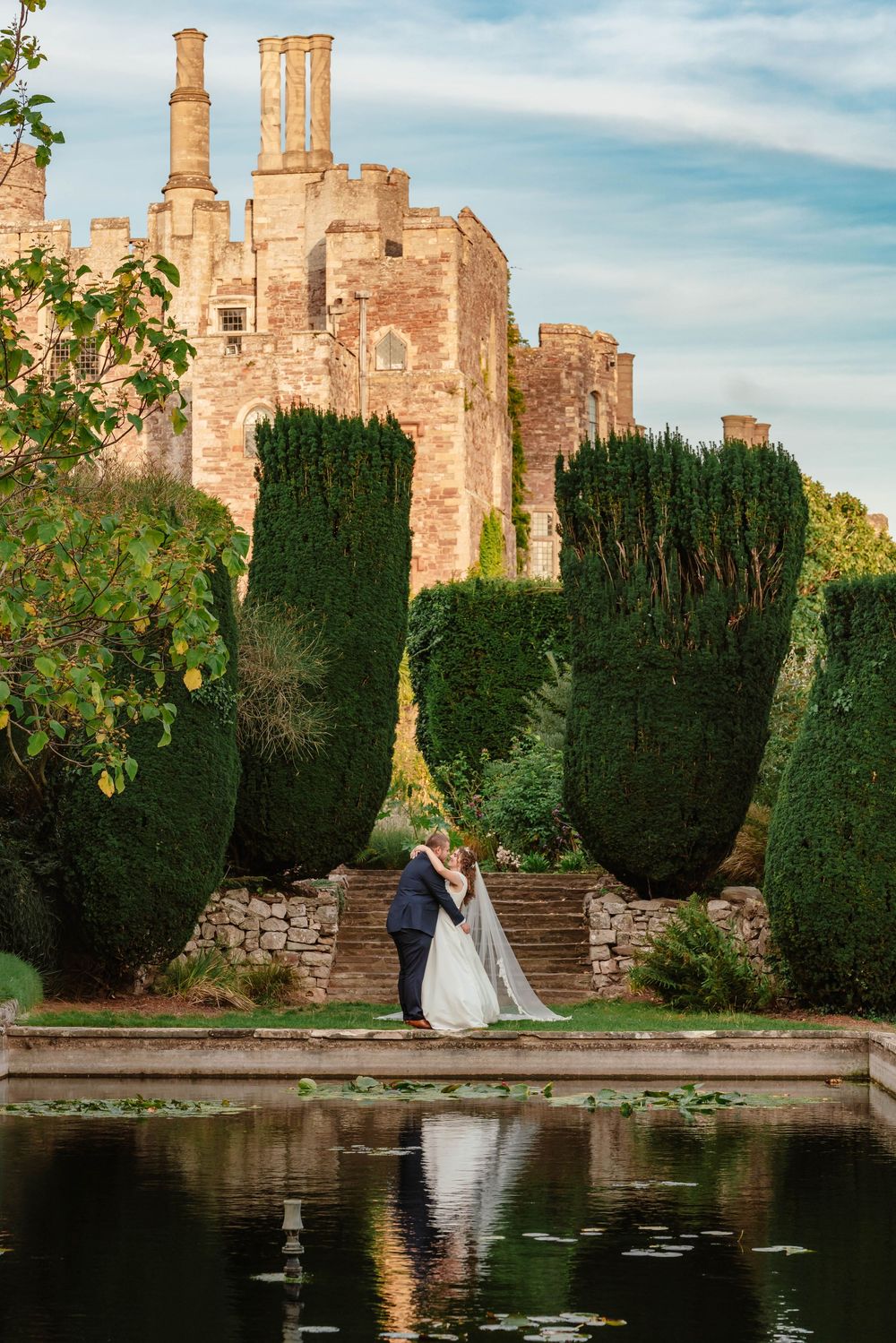 Sunset portraits at Berkeley Castle Gloucestershire Wedding bride and groom reflection in pond