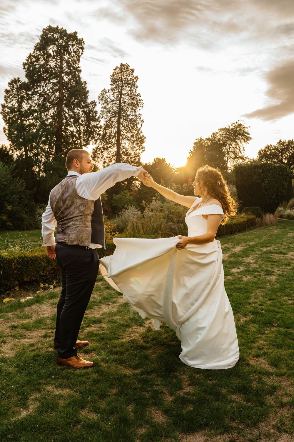Sunset portraits at Berkeley Castle Gloucestershire Wedding bride and groom twirl