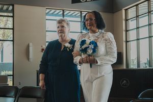 A couple shares a joyful moment during their wedding ceremony in a bright, window-lit venue.