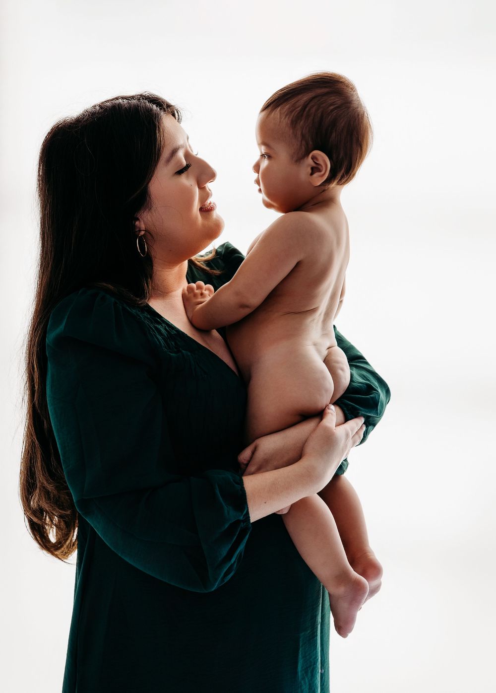 A tender moment captured in a series of black and white photos showing parent and child bonding against a light backdrop.