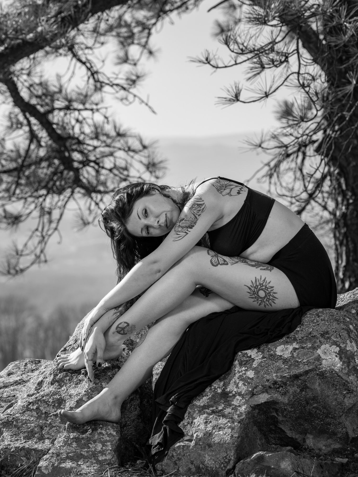 Female portrait of a woman leaning over a rock in the mouuntains