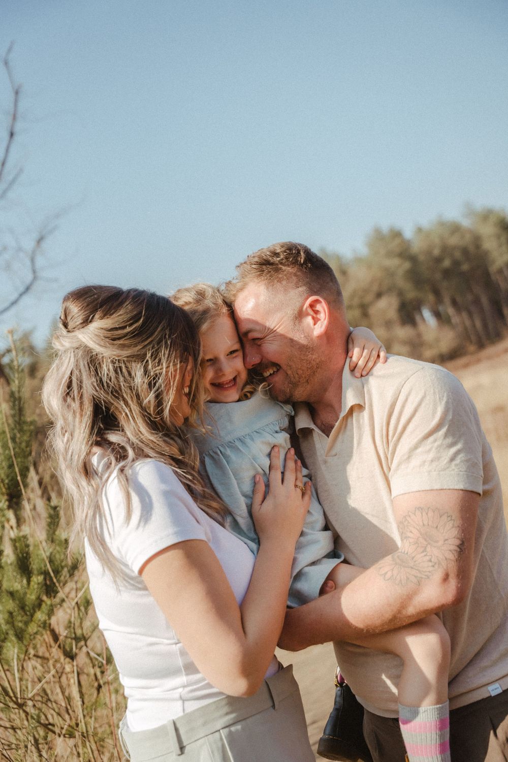 Family shares intimate moment together outdoors in natural setting.