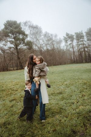 Family shares tender moments together on a misty hillside.