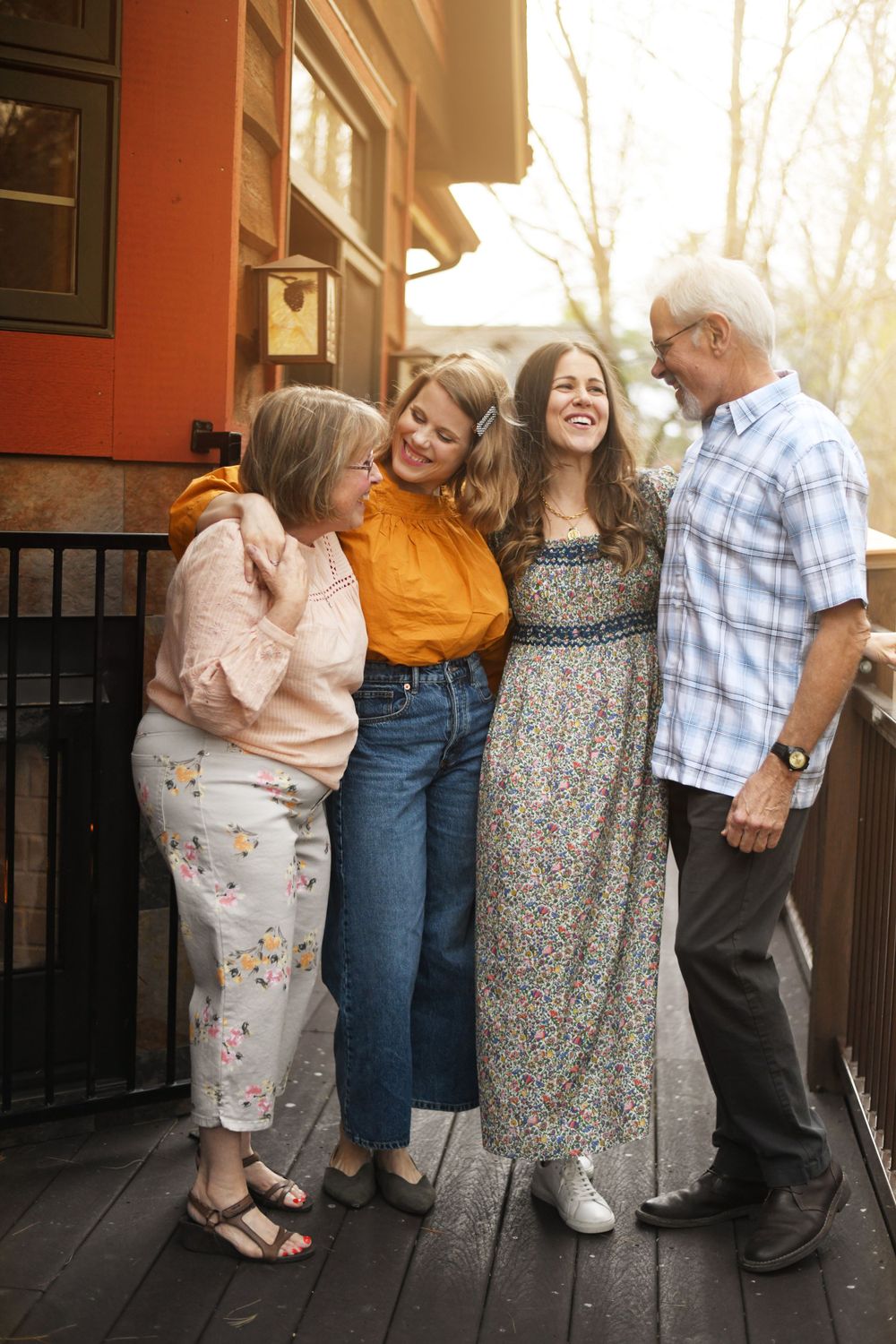 Group enjoying a candid moment together on an outdoor porch with warm sunset lighting.