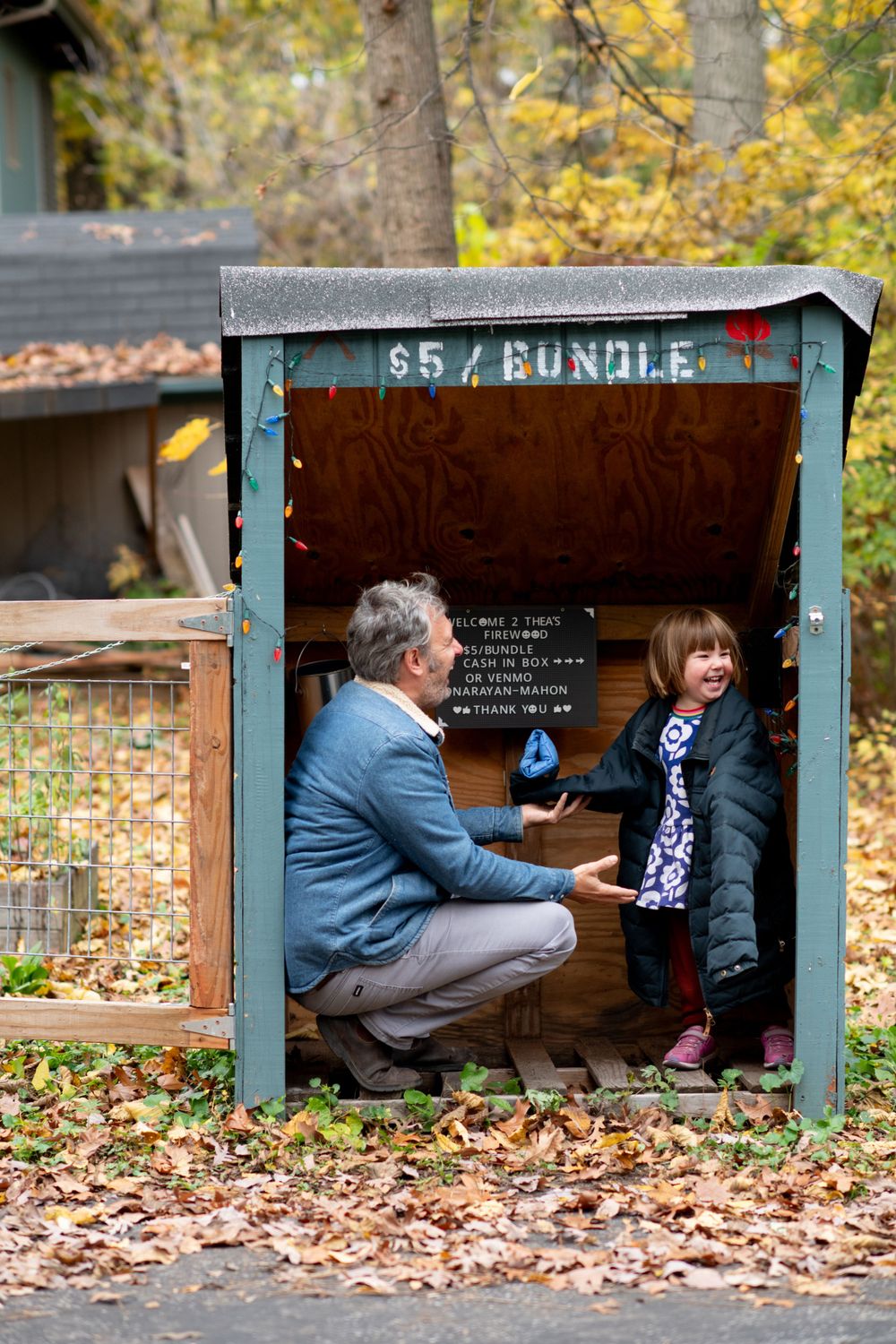 Fall scene with wooden bundle box shelter and fallen leaves.