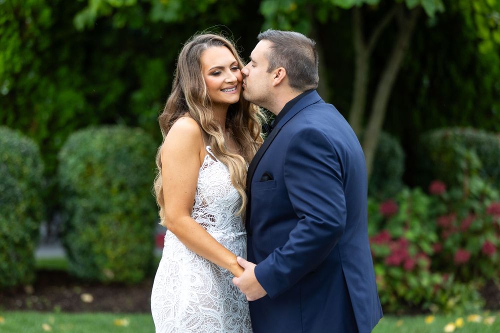 A romantic moment between newlyweds in a garden with blooming flowers.