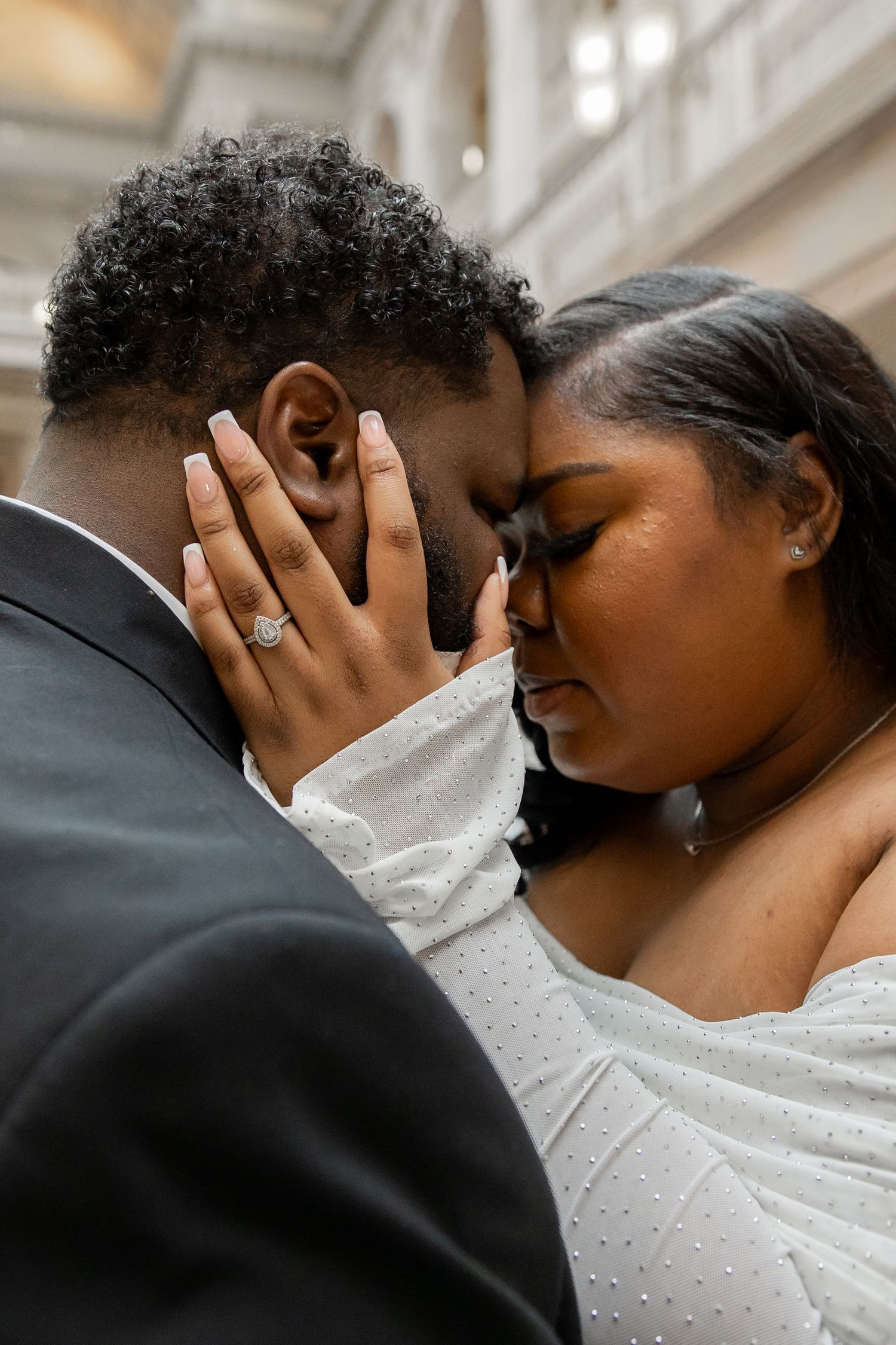 Intimate romantic moment captured in elegant venue with white interior design.