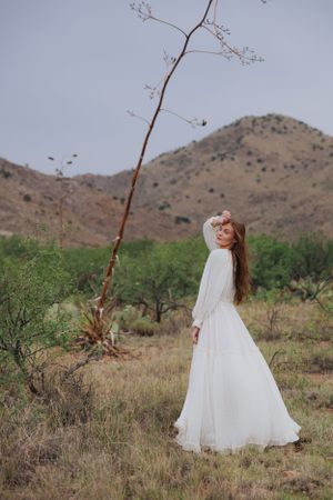 Ethereal white dress captured in motion against desert mountain landscape.