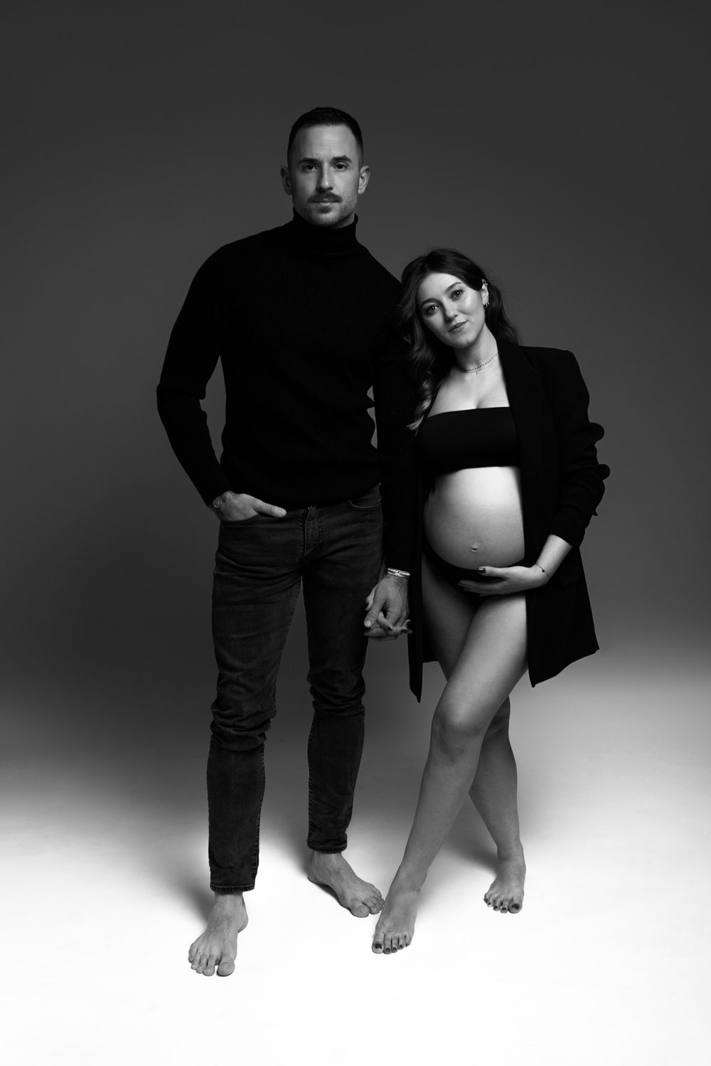 shooting grossesse couple classe ou le futur papa porte un joli col roulé et la future maman est en sous vetements