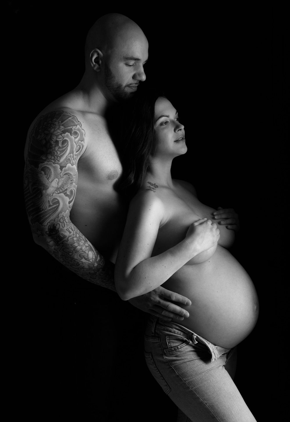 idee photo couple grossesse en noir et blanc avec un jeu de clair obscur mettant en valeur le ventre rond de la femme
