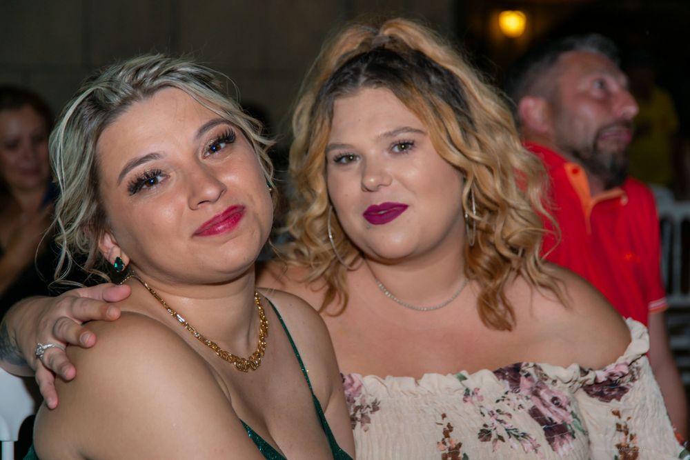 Two people making playful expressions while posing together at a festive event.