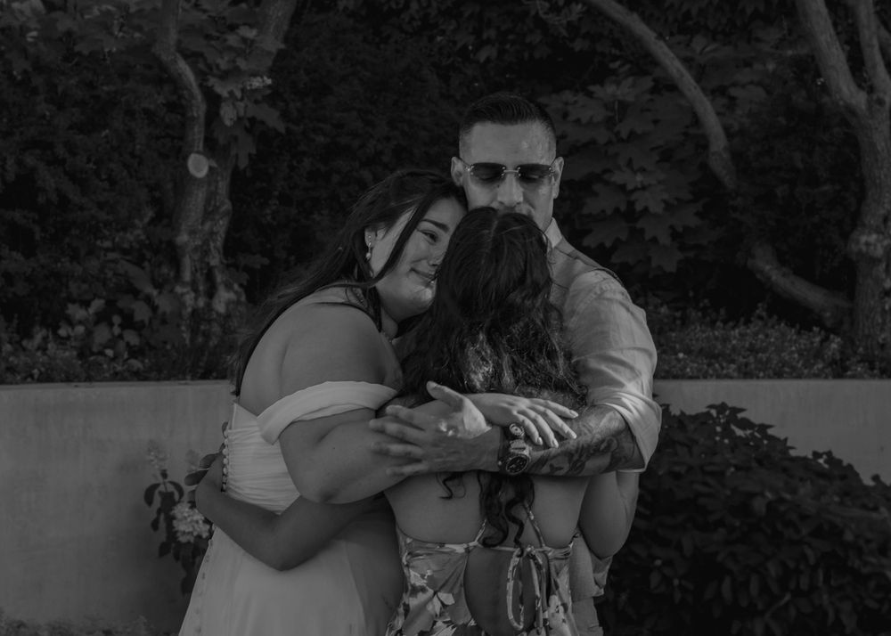 Bride, father, and sister during heartfelt moment while father-daughter dancing.