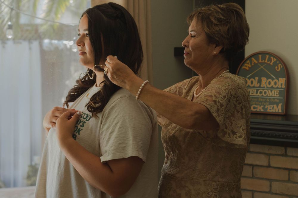 Grandma assisting bride with jewelry for the ceremony.
