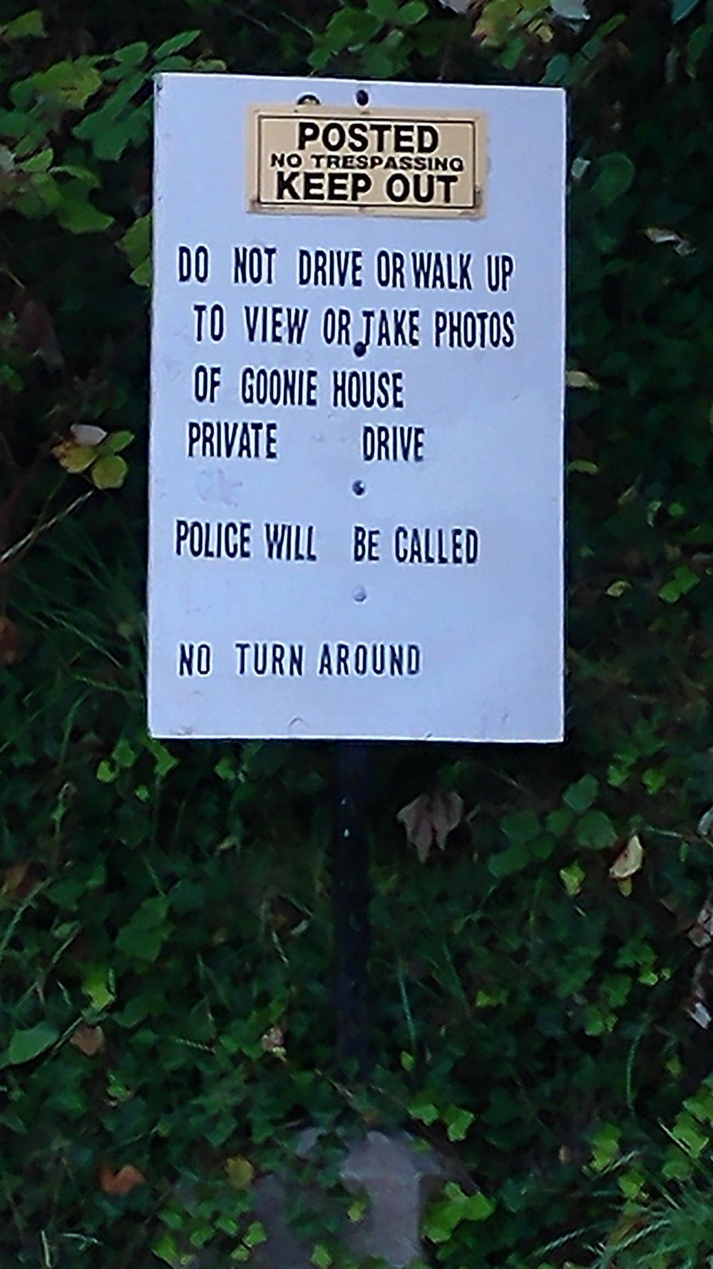 Posted warning sign for private drive with no trespassing instructions.