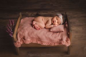 newborn baby laying naked in bed prop
