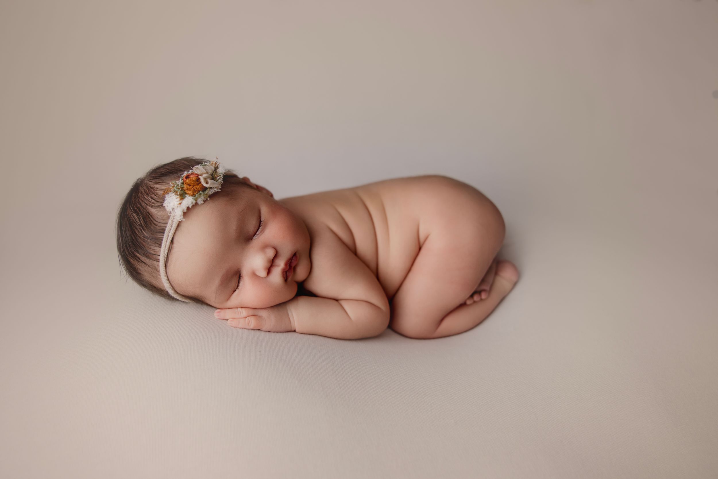Newborn baby laying on tummy studio photoshoot