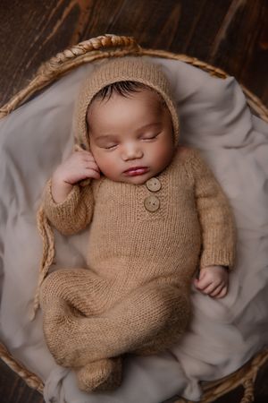 Baby laying in basket newborn photoshoot in Portland studio