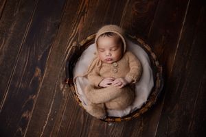 Newborn baby laying in wooden prop in Portland Oregon studio