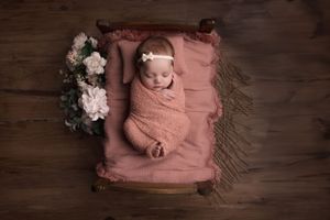 Newborn photography baby laying in bed prop with flowers