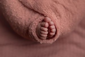 Newborn baby toes peeking out of swaddle for newborn photoshoot