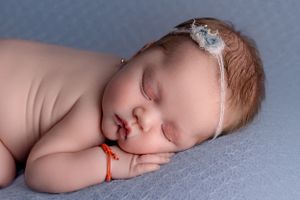 Newborn baby laying sideways on hand in Portland Oregon studio