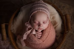 Baby swaddled inside of basket for newborn photography in Portland Oregon