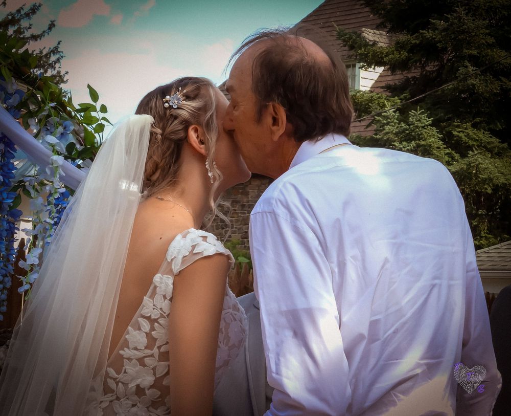 A tender moment captured at a wedding ceremony in front of a house.