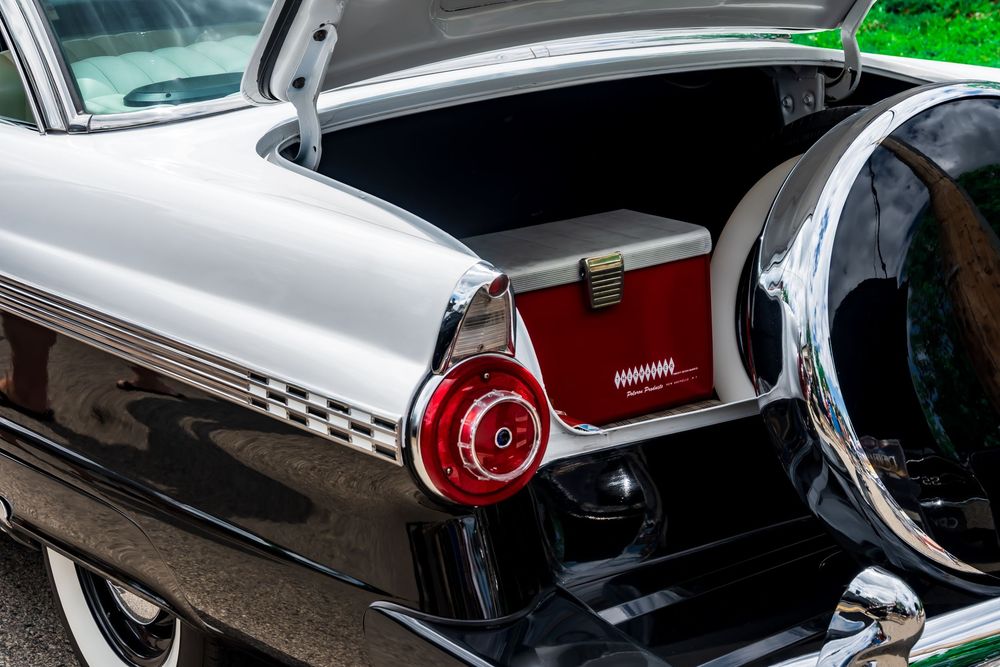 Classic car tail light detail with chrome trim and red lens.
