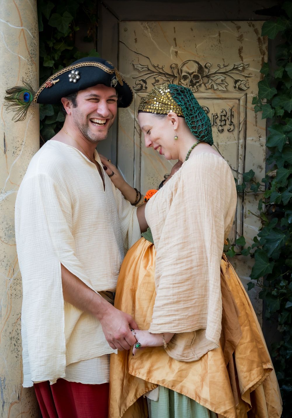 A couple in Renaissance period costumes share a tender moment at a historical reenactment event.