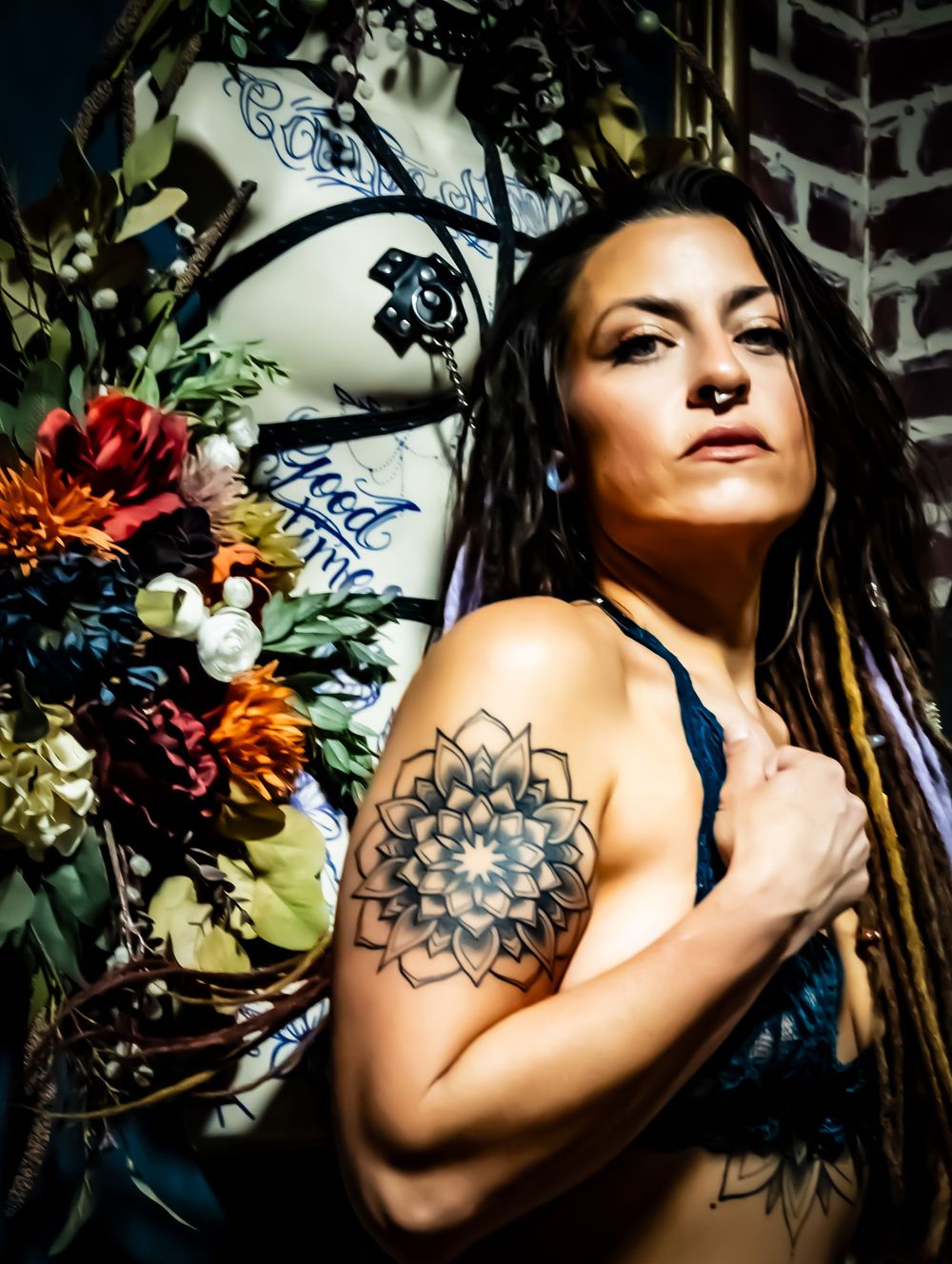 A series of artistic boudoir photos showing floral tattoo artwork on shoulder in moody lighting with natural elements.