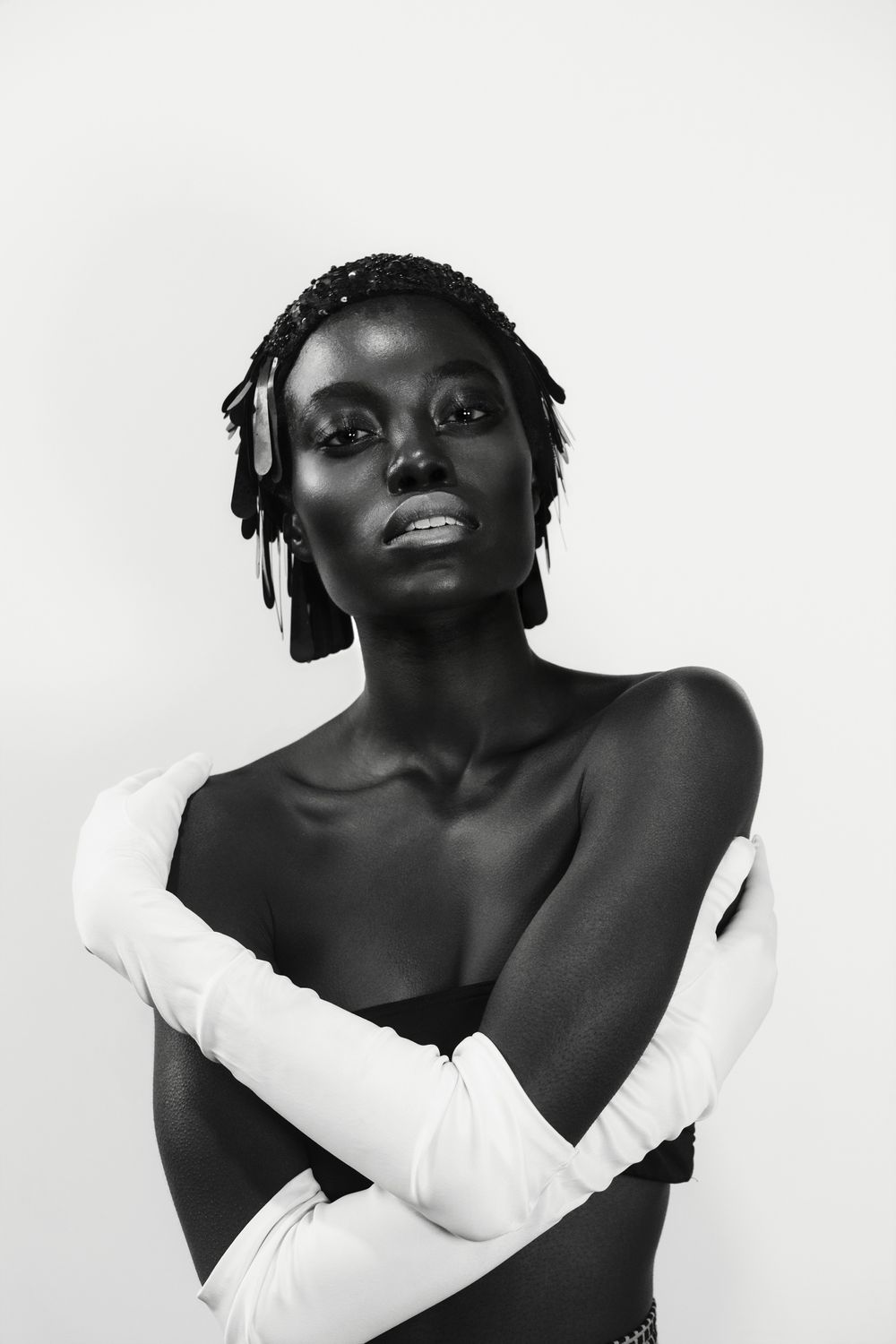Artistic black and white portrait showing elegant pose with white long gloves.