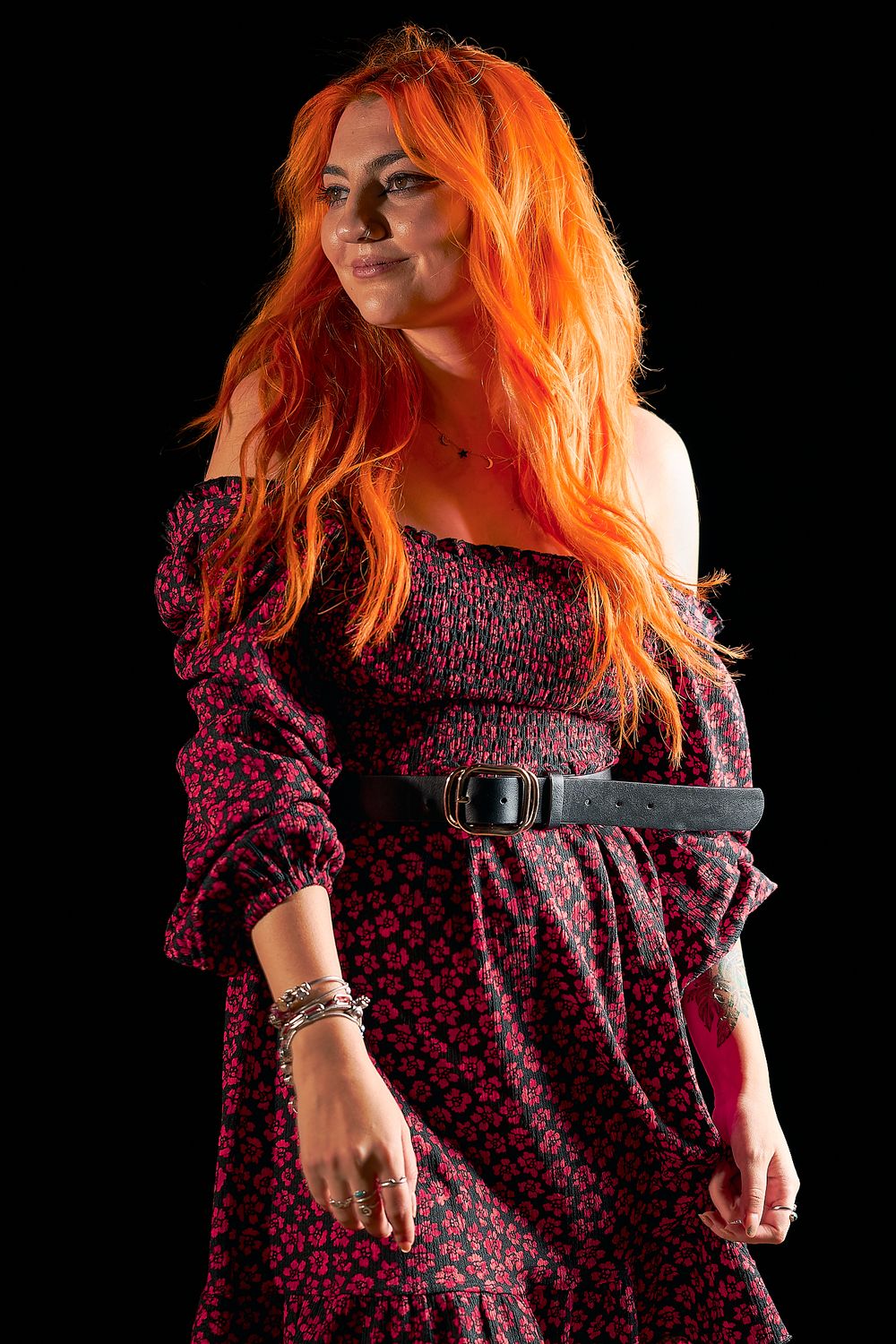 Fashion portrait showcasing flowing orange hair and burgundy floral dress with belt detail.
