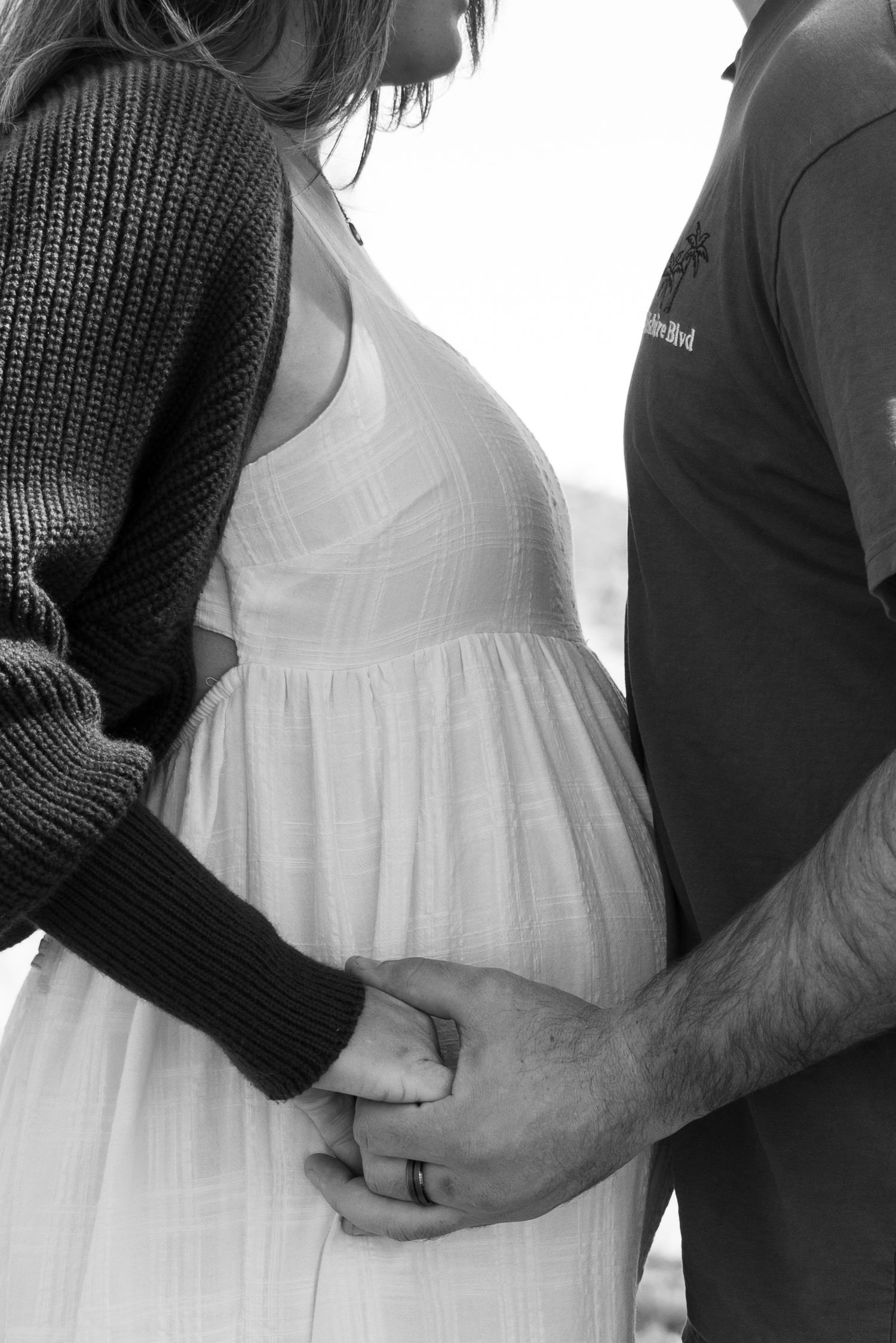 Someone holds a strip of ultrasound images showing developing baby scans.