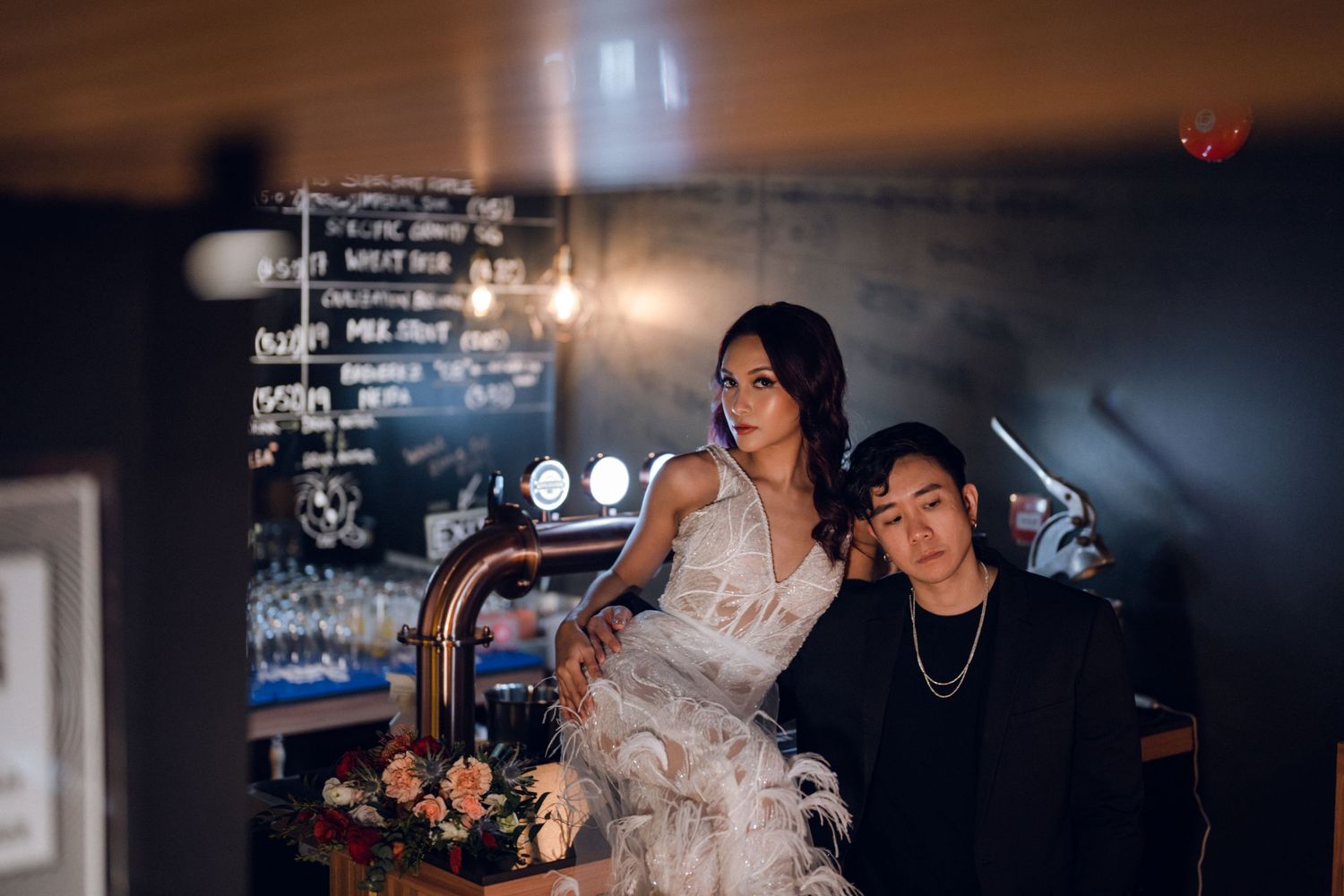 A couple shares an intimate moment in a cozy restaurant setting with dark ambiance.