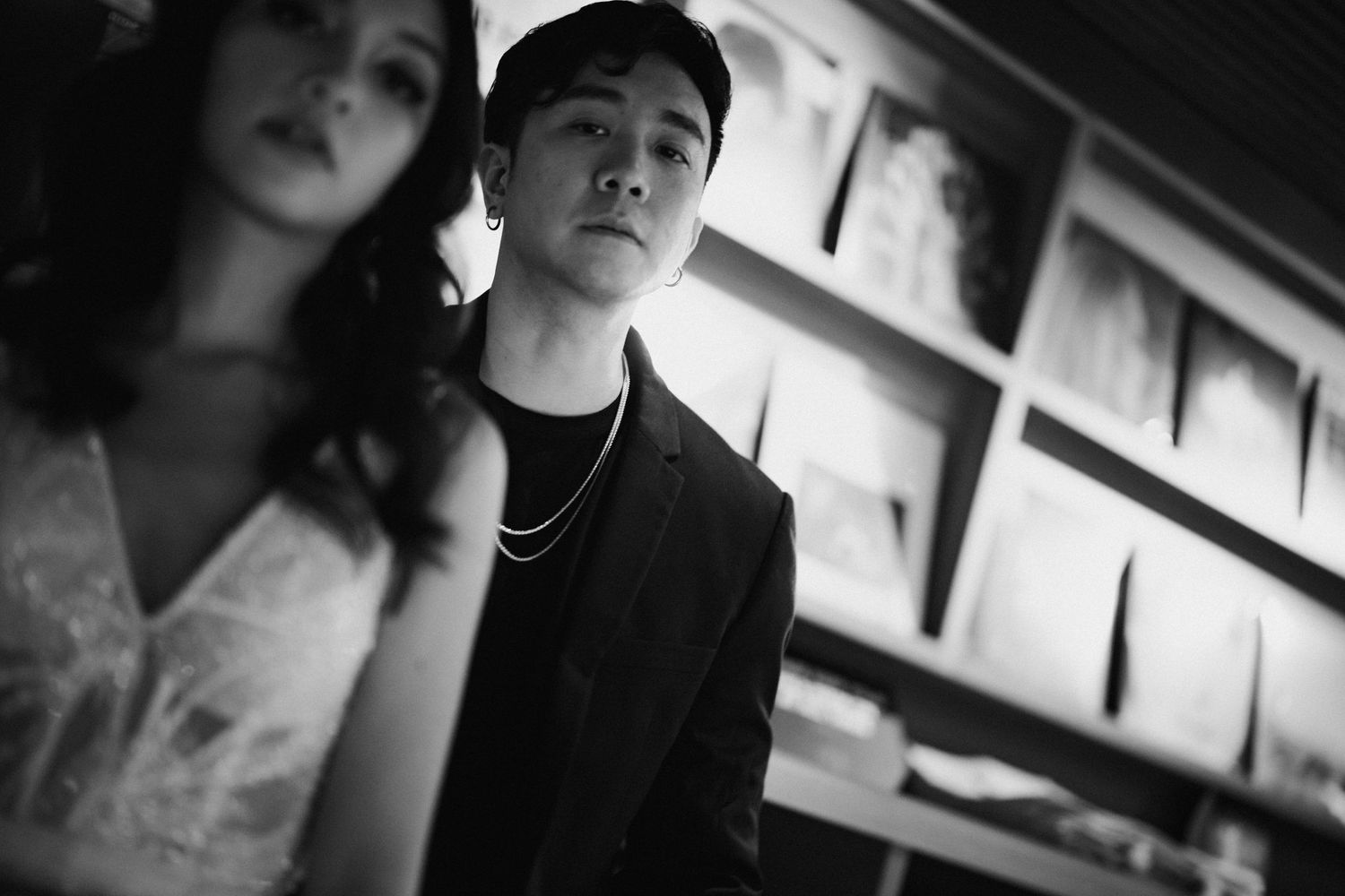 A moody black and white portrait in a restaurant setting with dramatic lighting.