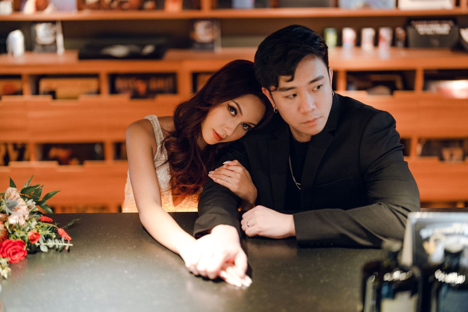 A couple shares tender moments at a restaurant table with warm ambient lighting.