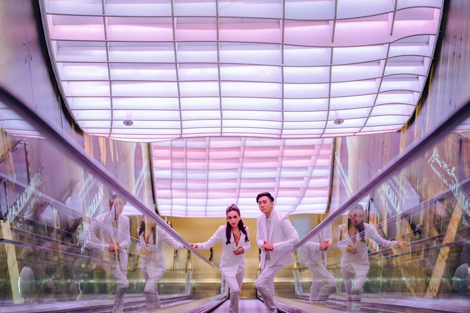 Sleek modern hallway with pink-tinted lighting and geometric patterns on ceiling.