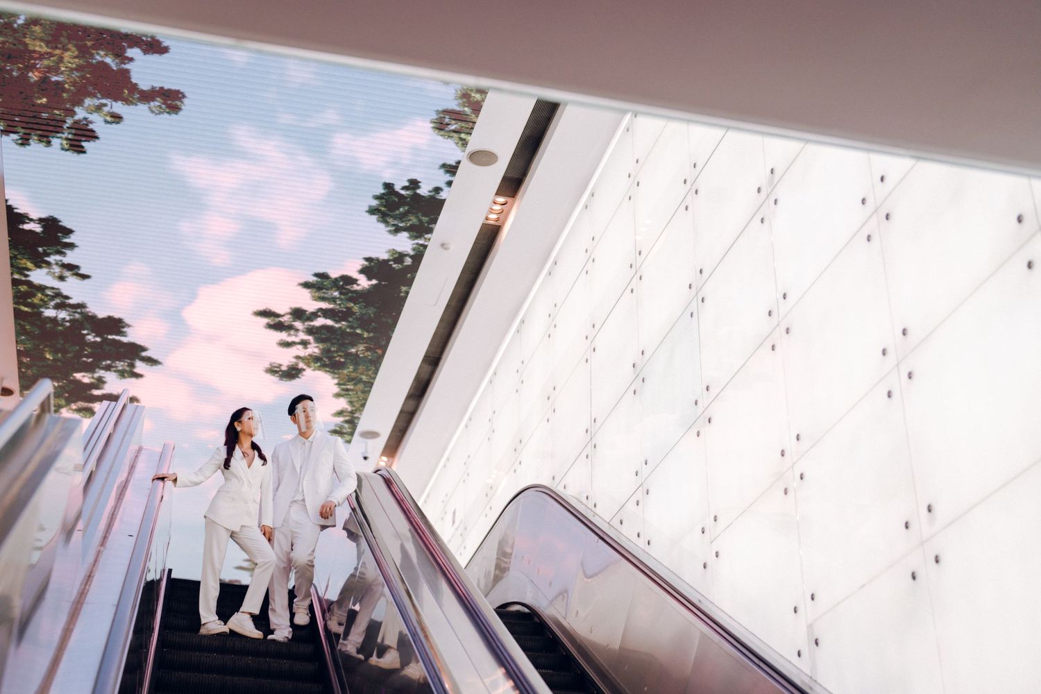 Modern architectural corridor with pink lighting and geometric ceiling design creates a futuristic atmosphere.