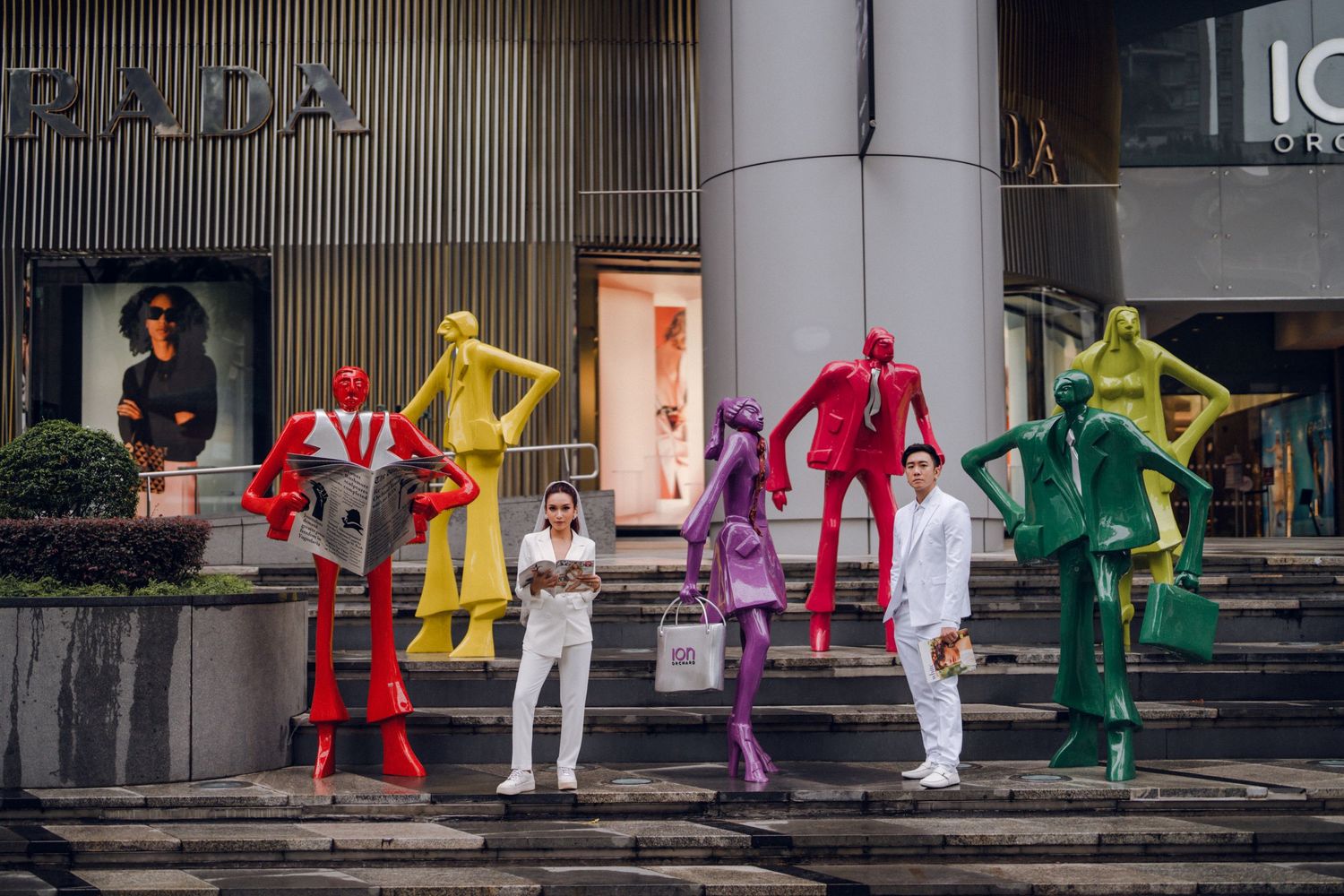 Colorful art installation featuring rainbow-colored figures outside retail space.