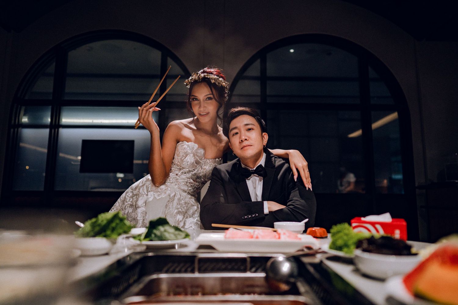 Elegant couple dines together at upscale restaurant with mood lighting.
