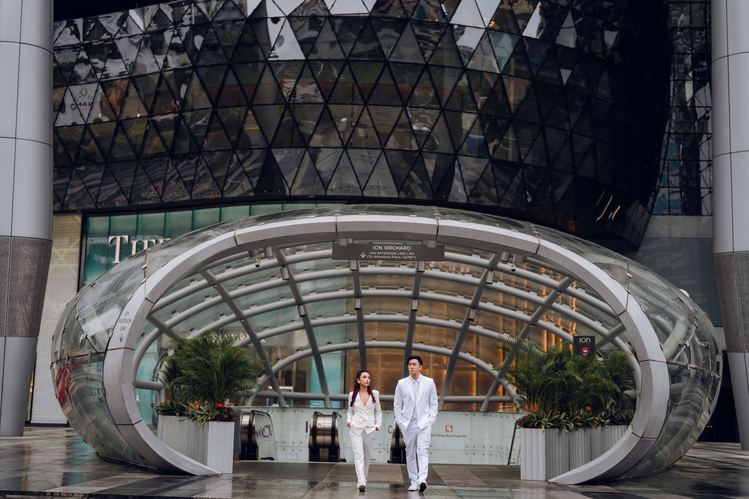 Contemporary building entrance with triangular geometric pattern and glass facade design.