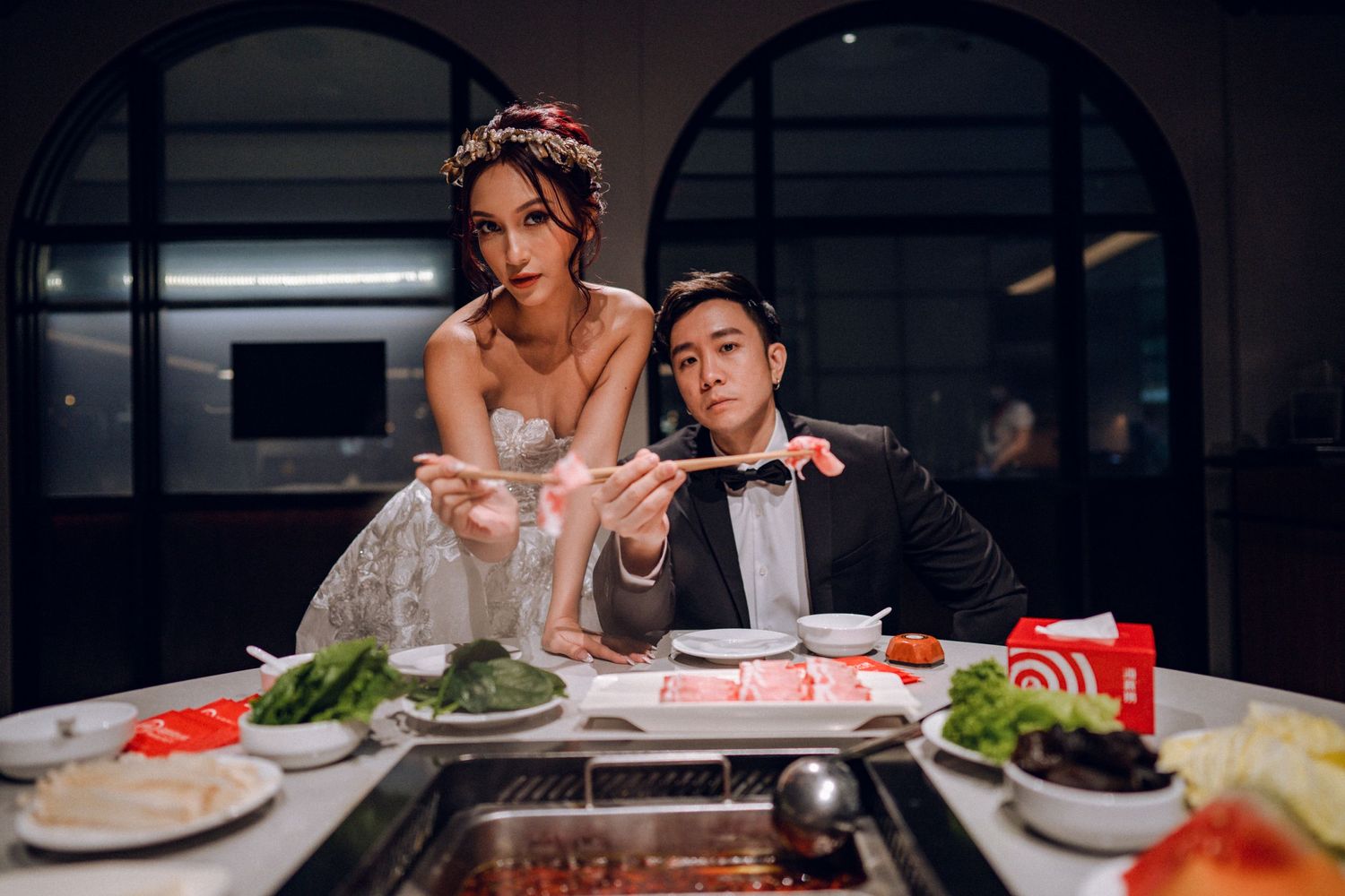 Couple enjoys hot pot dinner date in atmospheric restaurant setting.