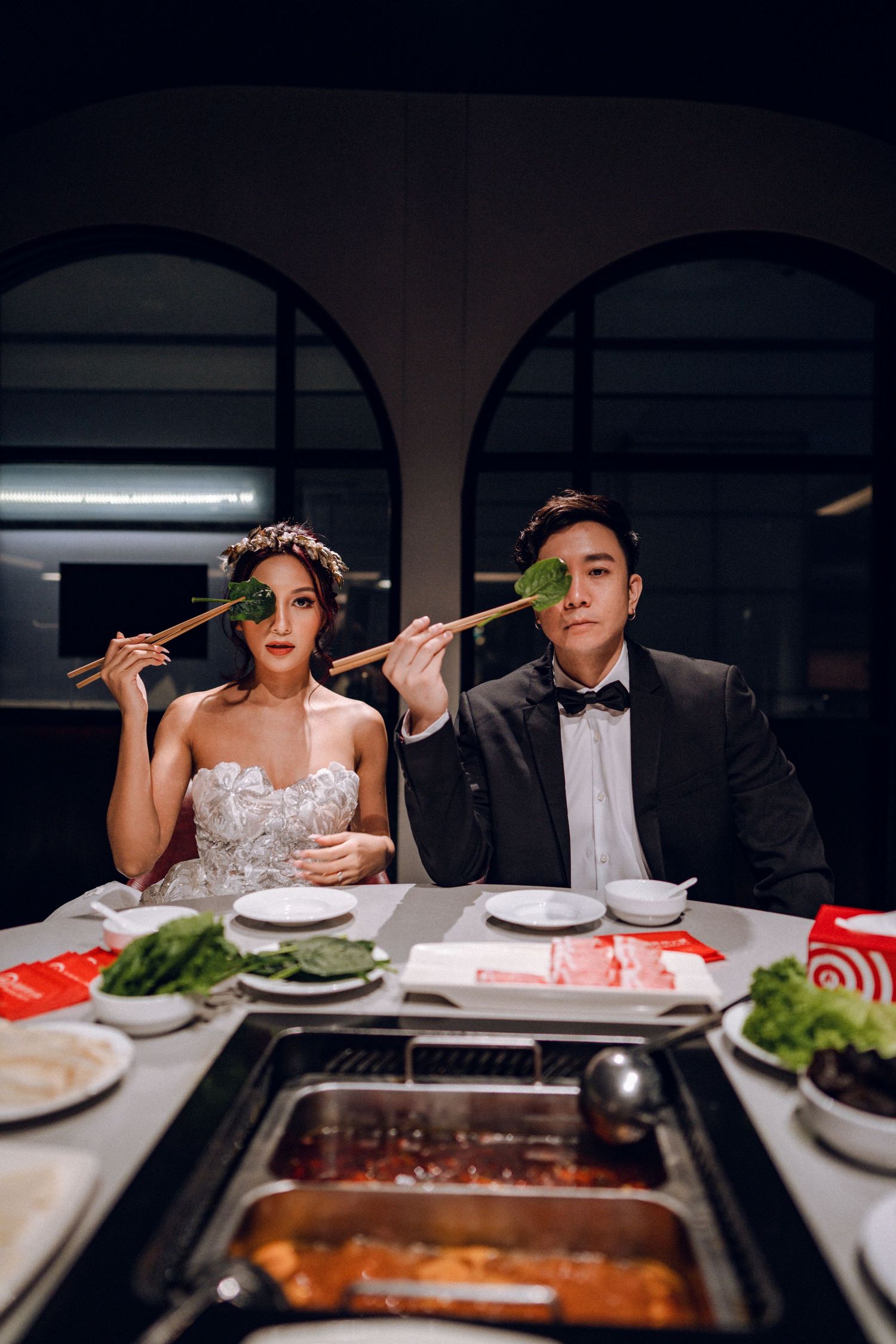 Playful couple uses chopsticks during romantic dinner date.