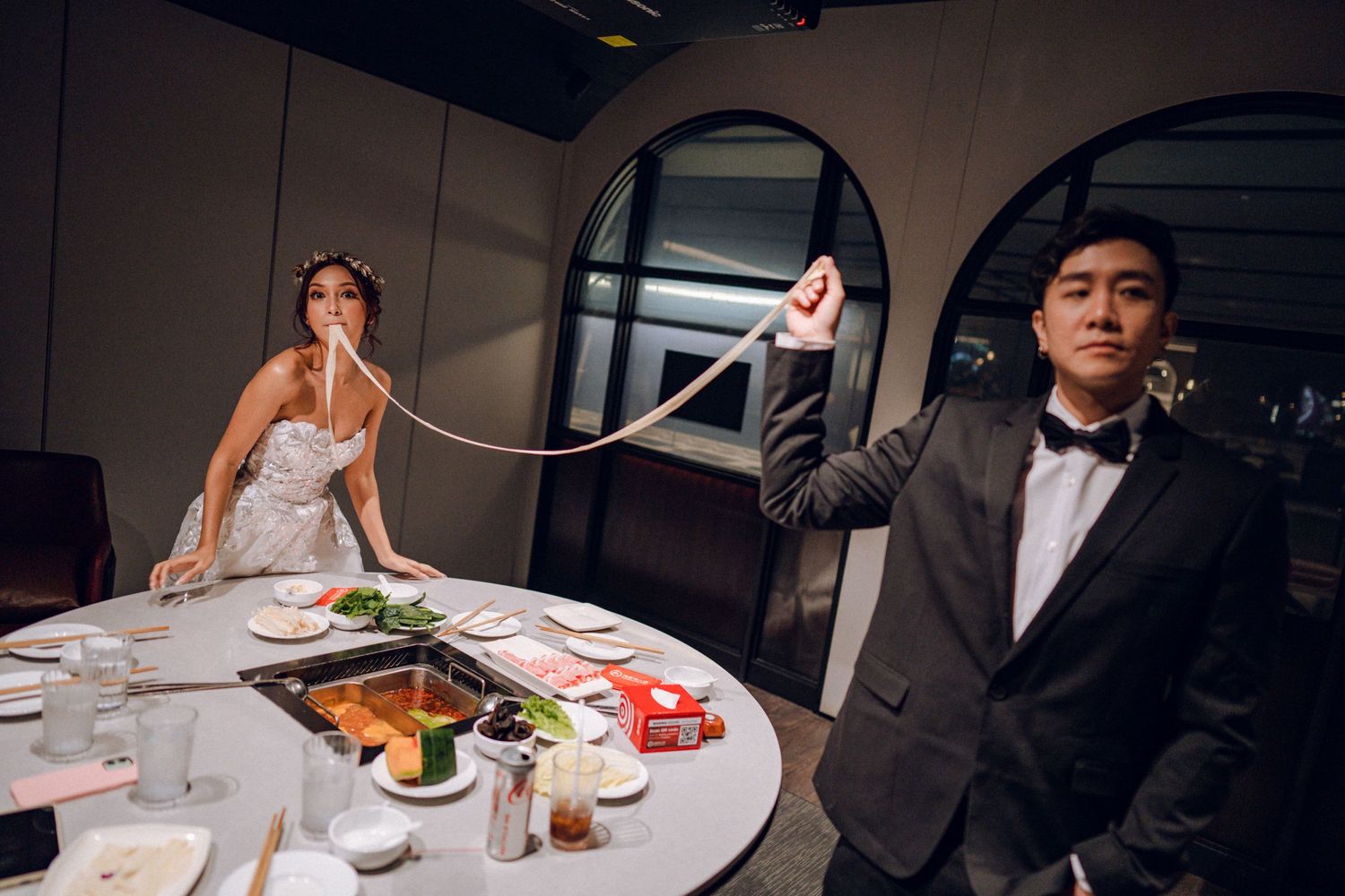 Romantic dinner setting with couple seated at round table featuring traditional Asian cuisine.