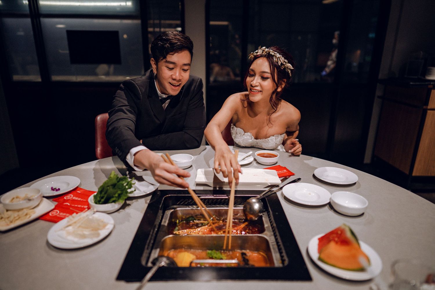 Couple sharing authentic Asian cuisine at an upscale restaurant with modern decor.