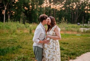 A couple in wedding attire share romantic moments in a rustic outdoor setting during golden hour.
