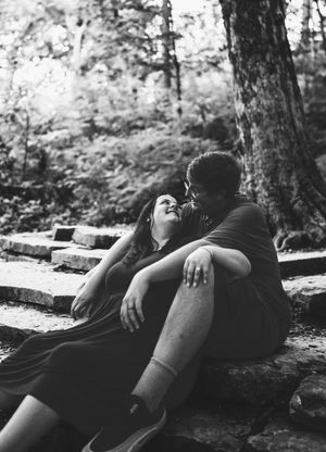 A black and white photo sequence showing two people lying together peacefully against a tree in a forest setting.