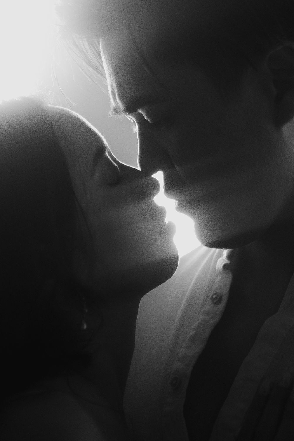 Artistic black and white silhouettes with dramatic backlighting creating romantic atmosphere.